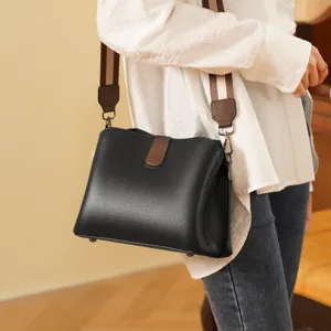 Elegante borsa a tracolla in pelle nera per donna con ampia tracolla a righe molto chic.
