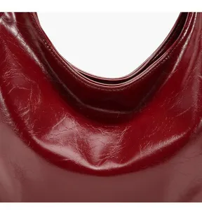 Red crinkled patent leather texture detail view of women shoulder underarm bag close-up