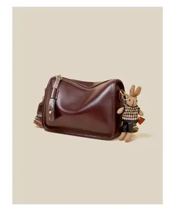 Vintage dark red shoulder bag with ethnic strap and cute rabbit pendant detail.