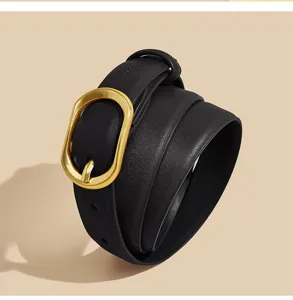 Gros plan sur la ceinture en cuir noir pour femme avec sa boucle ardillon dorée irrégulière.