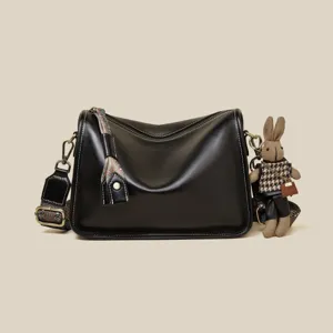 Chic black leather crossbody shoulder bag for women, retro style with cute rabbit charm.