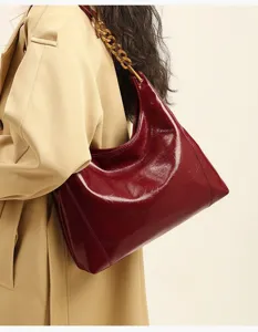 Red patent leather hobo shoulder bag detail, stylish chunky gold chain handle.