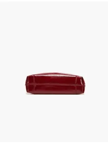 Detailed bottom view of elegant red patent leather women handbag, fine stitching.