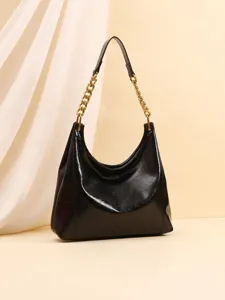 Black patent leather shoulder hobo bag featuring a chunky gold chain strap and sleek slouchy finish.