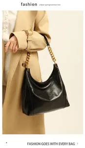 Detail shot of black hobo shoulder bag with chunky gold chain strap and soft crinkled leather.