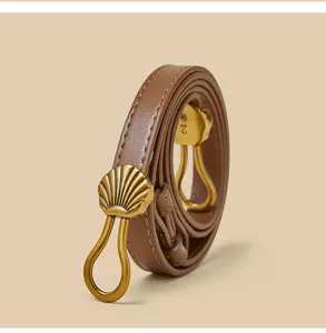 Gedetailleerd close-up van bruine lederen riem met unieke gouden schelp metalen gesp.