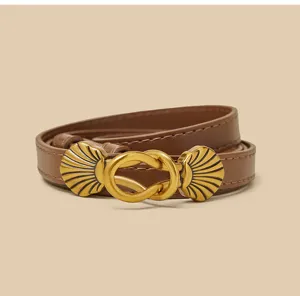 Detailopname van de bruine lederen riem met een retro gouden schelp gespontwerp.