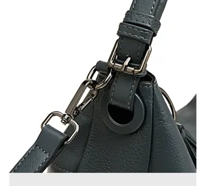 Detail shot of women's leather shoulder bag showing delicate metal hardware and stitching.