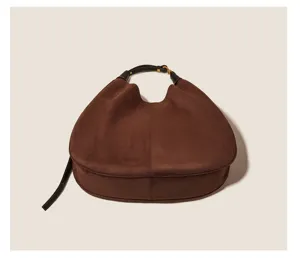 Detail view of brown suede slouchy shoulder bag featuring soft texture and dark strap.