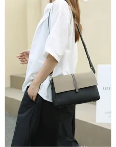 Close-up of the leather cross-body bag showing its chic color-block flap and metallic lock.