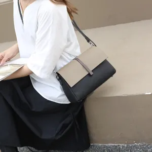 Two-tone leather crossbody shoulder bag for women stylish chic flap design with metal closure.