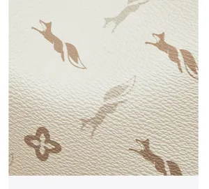Detailed view of the women's backpack material featuring monogram and fox pattern design.