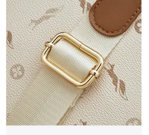 Close-up detail of women's stylish backpack strap with gold metal buckle and leather trim.