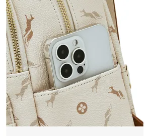 Detailed view of women's chic monogram backpack front pocket with phone slot and metal zippers.