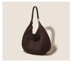 Brown suede hobo shoulder bag detail showcasing slouchy design and metal ring strap.