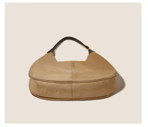 Khaki suede shoulder bag, vintage hobo design with dark brown handle, detailed texture view.