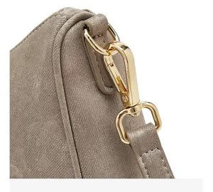 Detailopname van de gouden metalen sluiting en de schouderband van de elegante satin tas.