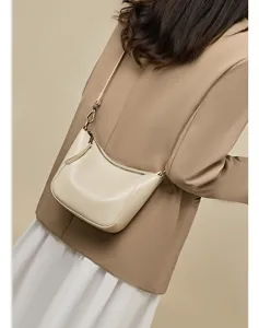 Detailansicht der eleganten beige Leder Umhängetasche im Halbmond-Design am Model.