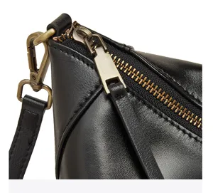 Schwarze Echtleder-Dumpling-Tasche Detail, Messing-Reißverschluss und Riemen-Hardware.