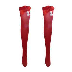 Rote Weihnachtskniestrümpfe mit hübscher roter Schleife und weißen Bommeln für Party.
