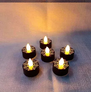 Halloween electronic tealight candles with spiderweb pattern, warm yellow LED light for party.