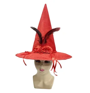 Primer plano del sombrero de bruja rojo con rosas de satén, pluma negra y terciopelo.