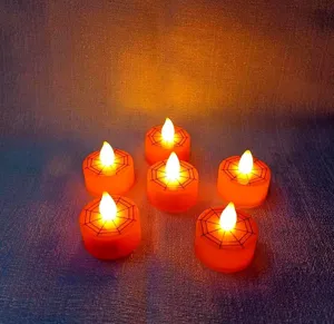 Detail view of Halloween LED tealight candles with spooky spiderweb pattern and warm light.