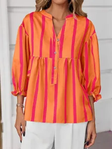 Close-up detail of the orange and pink striped blouse with V-neck and button front.
