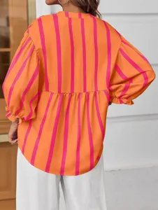 Detailed view of women's orange and pink striped long sleeve loose blouse with gathered waist.