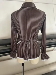 Detailed view of women striped long sleeve blouse with lace up back and ruffle cuffs.