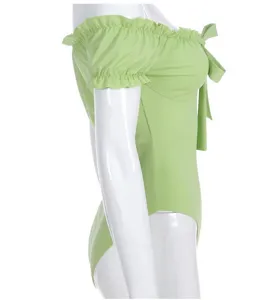 Detail view of light green off-the-shoulder bodysuit with ruffles and cute front bow tie.