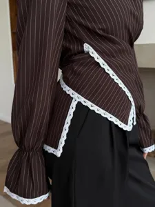 Brown pinstripe long sleeve blouse detail featuring delicate white lace trim and wrap waist design.