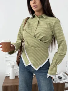 Close-up of women's green striped long sleeve crossover shirt with lace hem details.