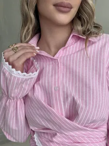 Close-up detail of the pink and white striped long sleeve shirt with lace cuff design.