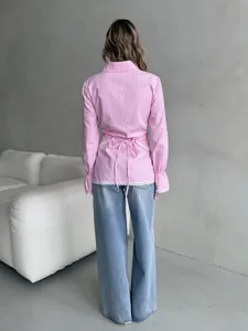 Pink striped long-sleeve blouse showcasing a stylish waist tie and delicate lace hem details.