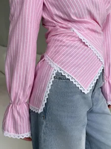 Detailed view of pink and white striped wrap long sleeve shirt with delicate white lace trim.