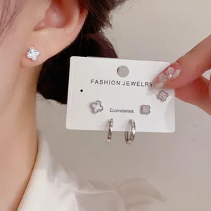Detail shot of clover stud and hoop earrings set, featuring mother of pearl and zircon.