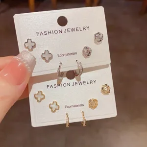 Detailed view of fashion clover and flower stud earrings set with crystal hoops, chic jewelry.