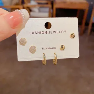 Detailed view of minimalist rhinestone square earrings and hoop set on display card.