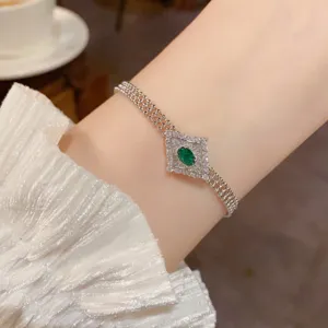 Primo piano del raffinato bracciale in zircone con pietra verde a rombo e catena fine.