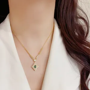 Primo piano dettagliato della collana con ciondolo a rombo vintage con pietra verde.
