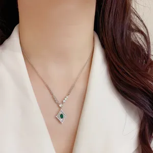 Primo piano dettagliato della collana retrò in zircone con pietra centrale verde brillante.