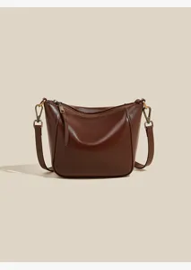 Brown leather shoulder bag detail showing premium texture and metal zipper hardware design.