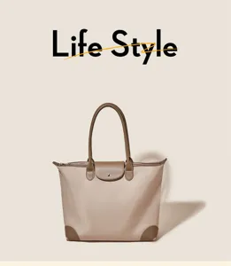 Nylon tote bag detail showing durable brown leather handles and waterproof fabric.