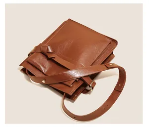 Detailed close-up view of the stylish brown leather shoulder bag, featuring unique knot strap.