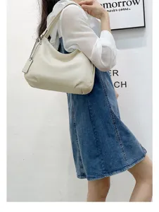 Detailed view of genuine leather hobo shoulder bag showing soft texture and stylish hangtag.