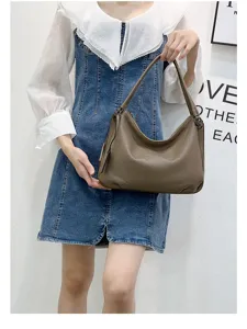 Detailed view of genuine leather brown hobo shoulder bag, soft cowhide texture and zipper.