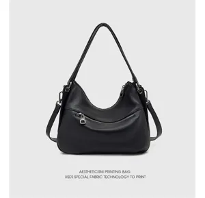 Detail view of stylish black genuine leather shoulder bag with zipper pocket and hardware.
