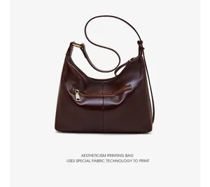 Detailed view of the dark brown leather hobo shoulder bag featuring fine texture and metal zipper.