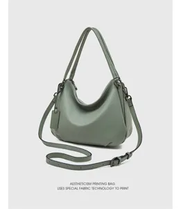 Close up of genuine leather hobo shoulder bag detail, elegant green texture and metal hardware.
